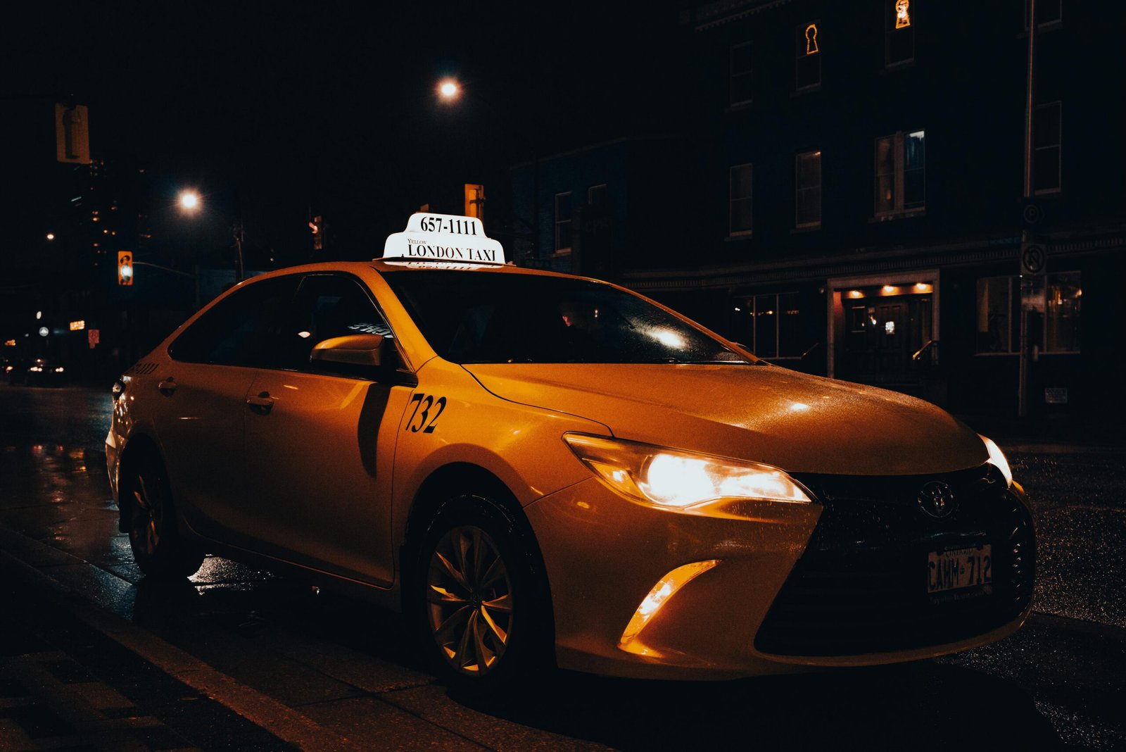 Services A yellow taxi waiting at night in London, Ontario, Canada. Urban transportation captured with street lights.