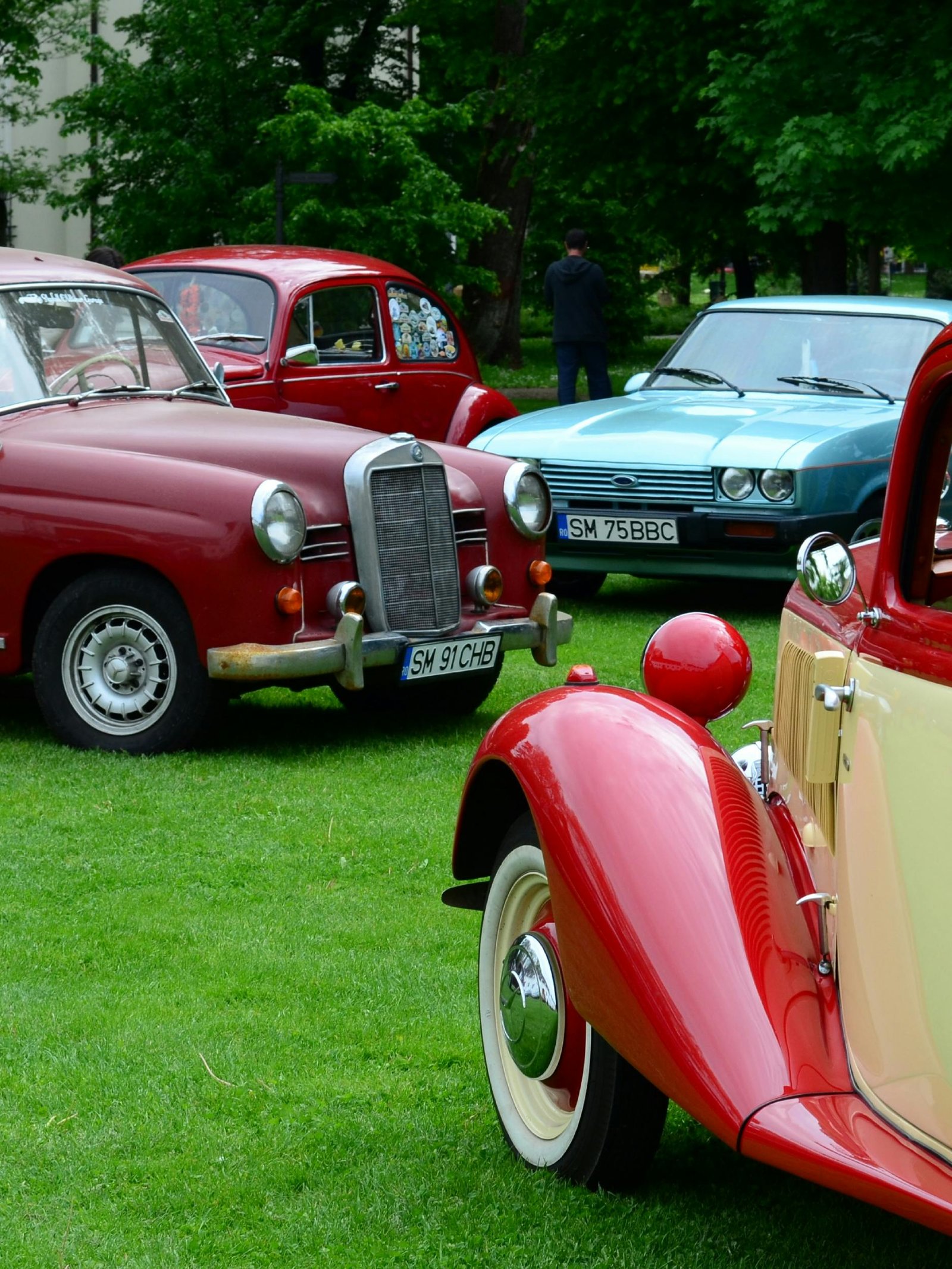 Home A vibrant display of classic vintage cars at an outdoor exhibition.
