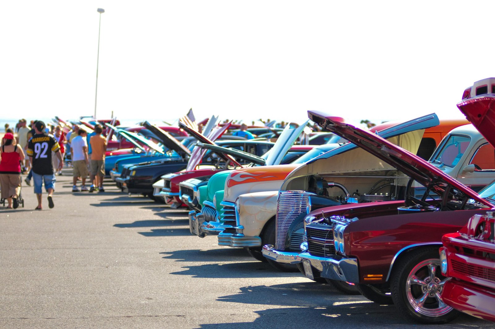 Home Colorful classic cars on display outdoors at a sunny car show.