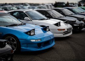 Home Toyota MR2 sports cars with popup headlights showcased at a car meet in England.