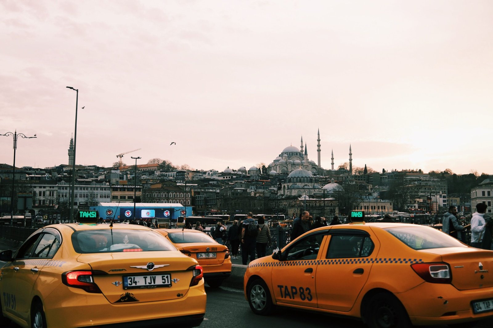 Yellow taxis navigate busy Istanbul streets with iconic mosques in the background.